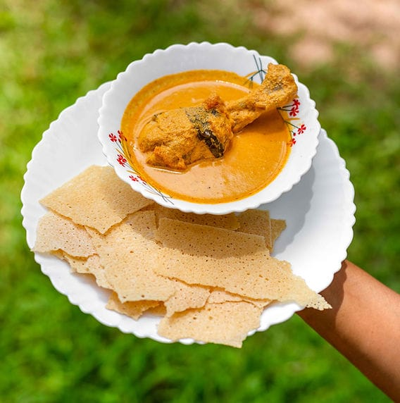 Crispy rice rotti wafers served with spicy Mangalorean chicken curry
